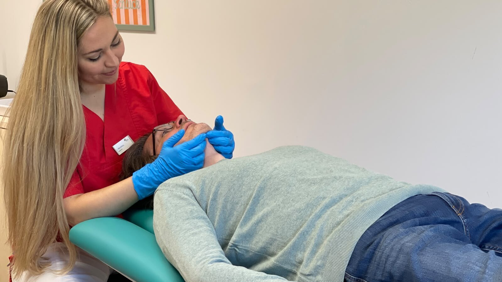 Logopädin nimmt eine Kieferbehandlung am Patienten vor